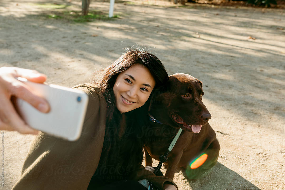 asian woman and her labrador dog taking a selfie