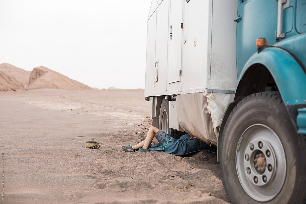 woman deflating air from tyres from a camping truck in the desert
