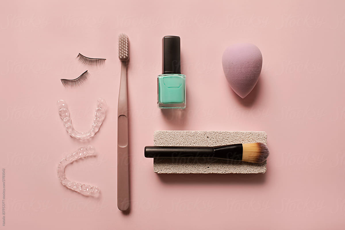 Beauty products arranged as a still life flatlay with lear dental teeth aligner on pink background