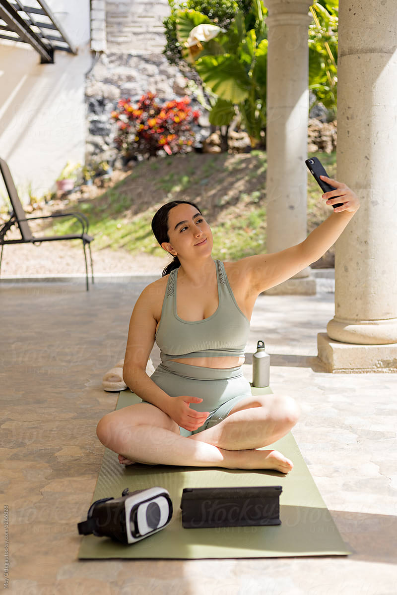 Woman Taking A Selfie While Exercising In Her Backyard