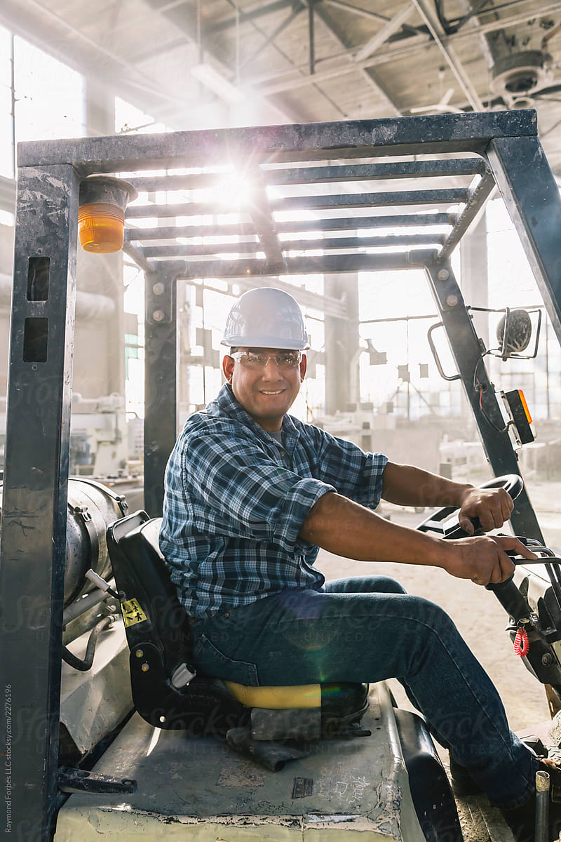 Portrait of Hispanic Worker driving Forklift