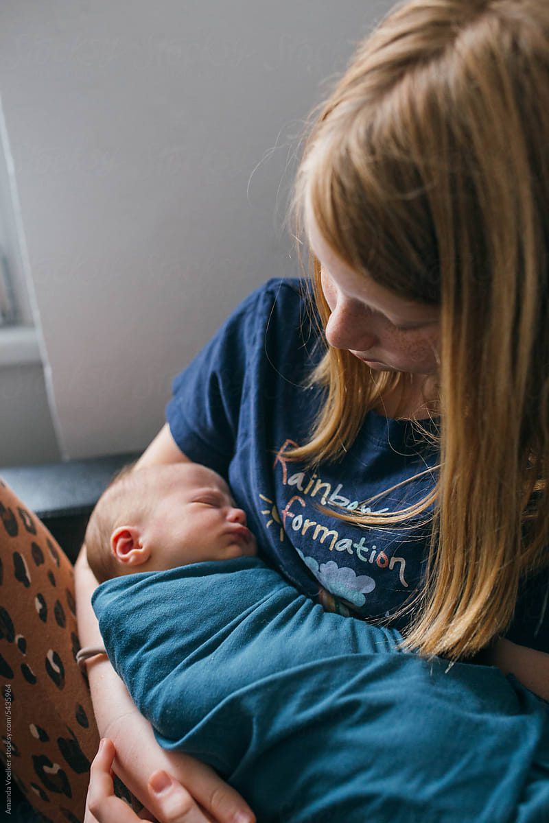 Little girl holding newborn baby