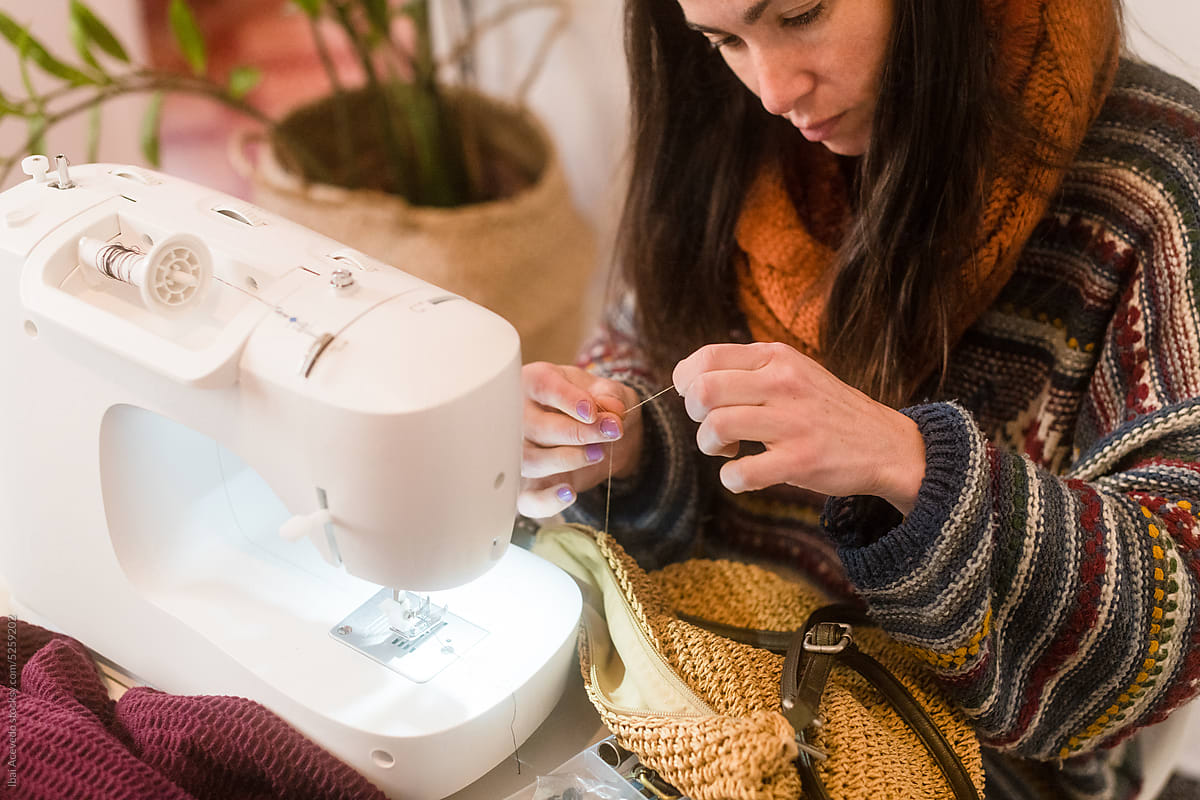 Woman sewing handbag at home