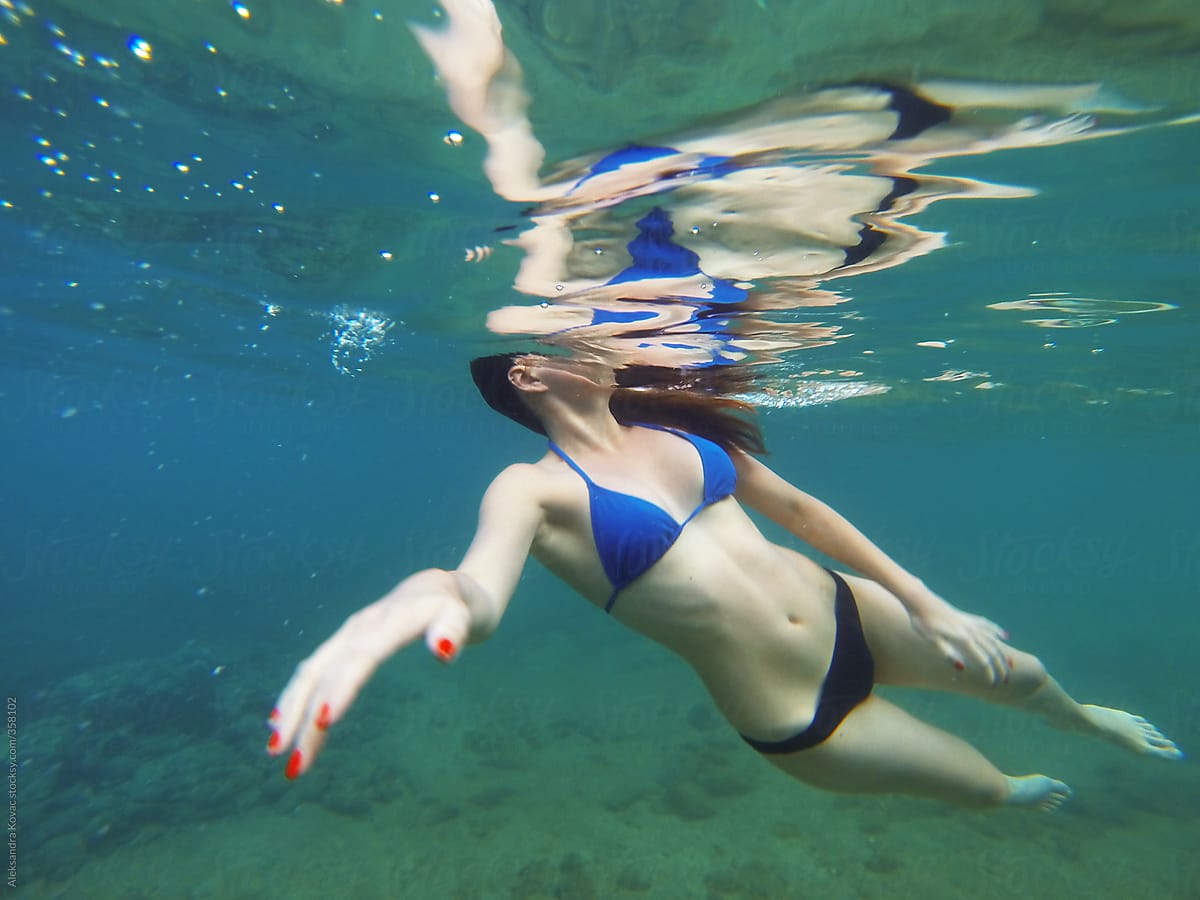 Woman in swimsuit is swiming underwater