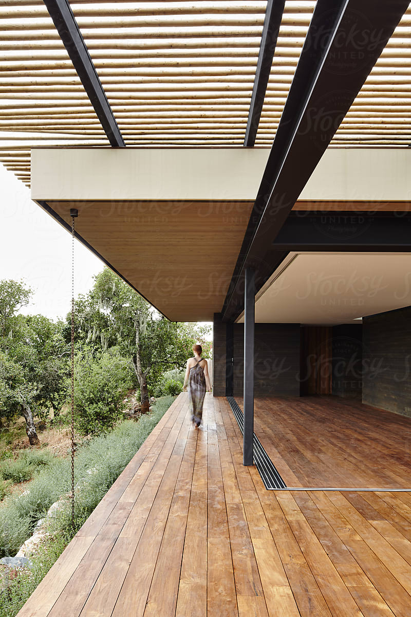Woman walking on indoor/outdoor deck at modern design home