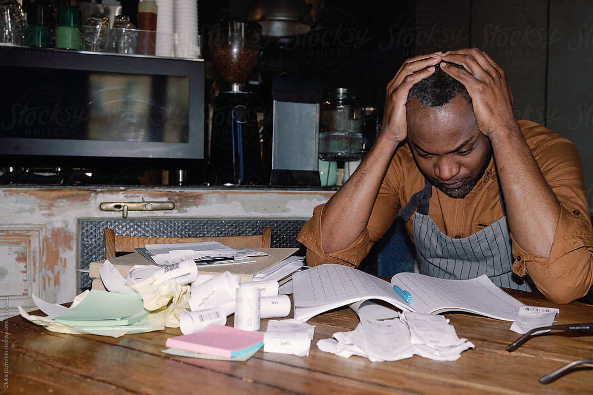 Stressed Cafe Owner Amidst Business Paperwork