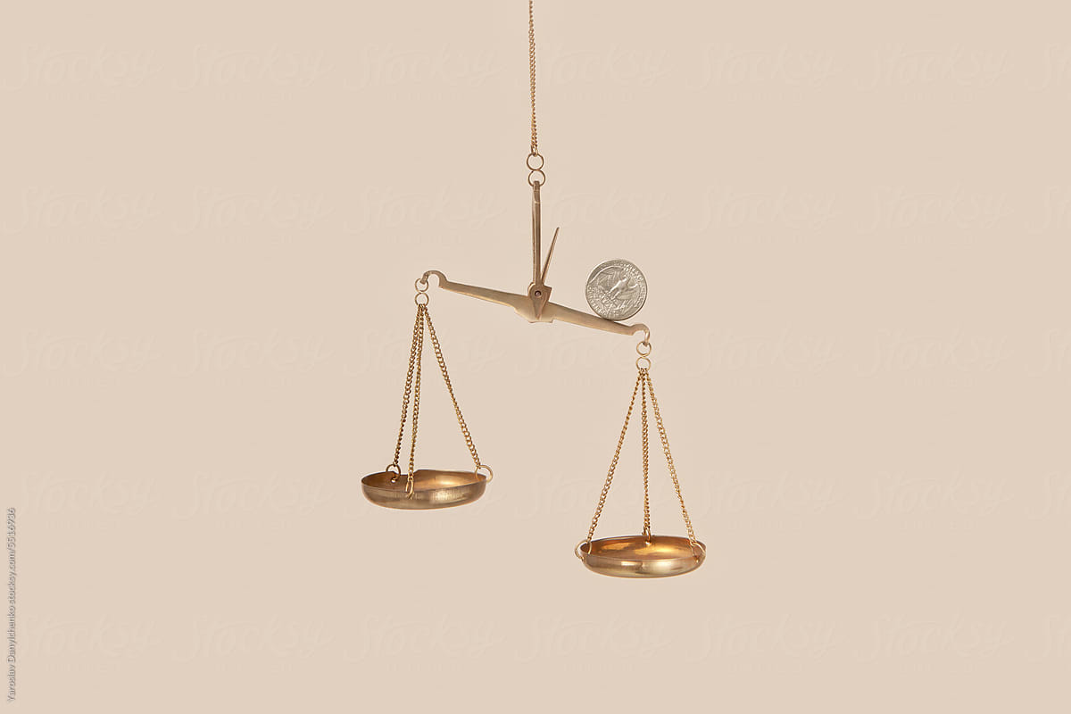 Coin on top of golden empty scales.