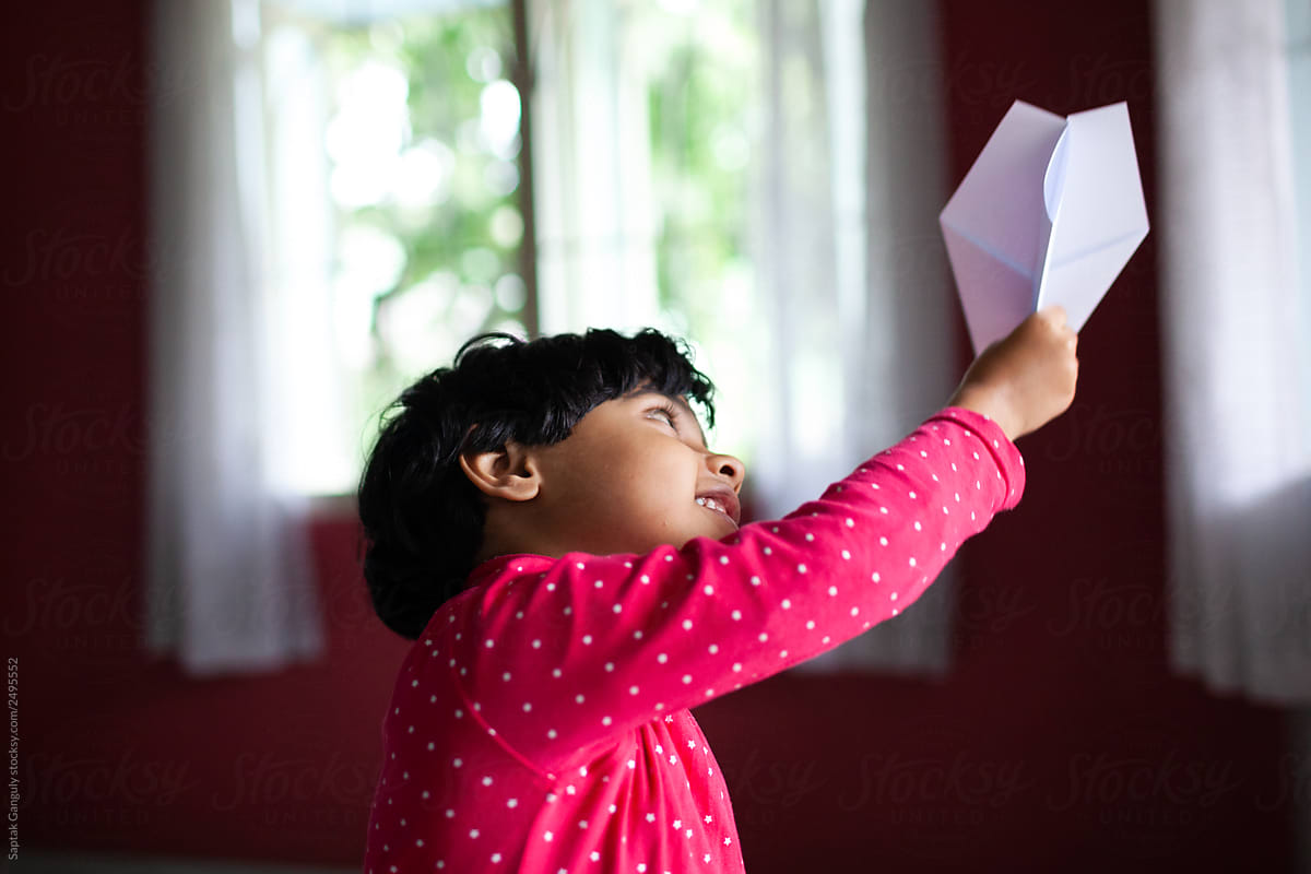 Little girl playing with paper plane
