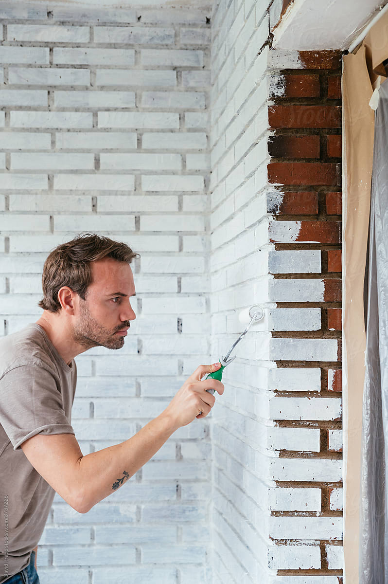 Man painting wall at home