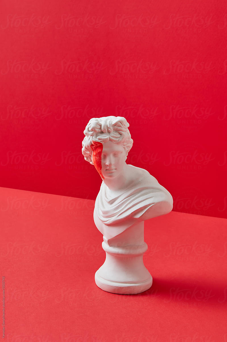 Plaster goddess statue with red paint on the face.