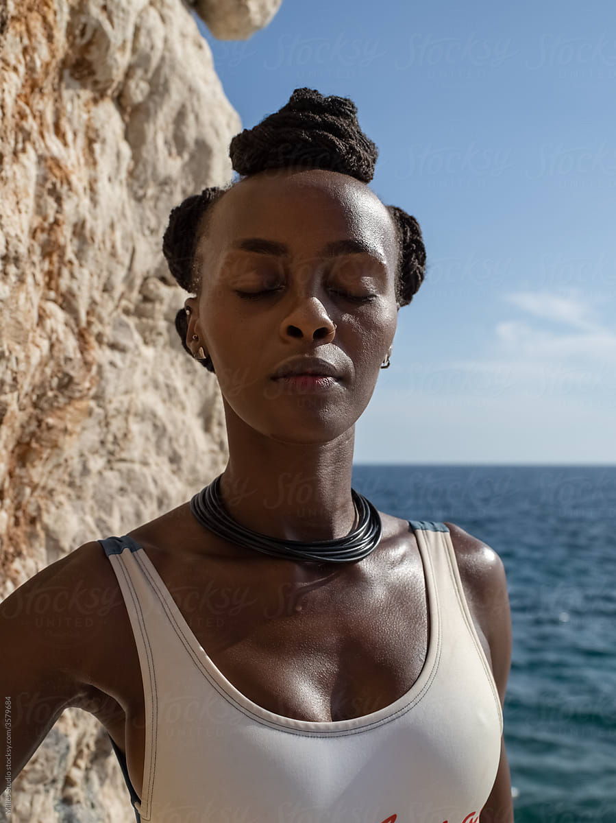 Black woman breathing near sea