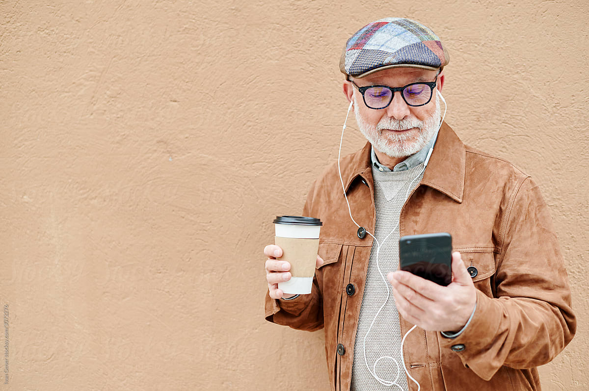 Senior man drinking coffee and using a cellphone