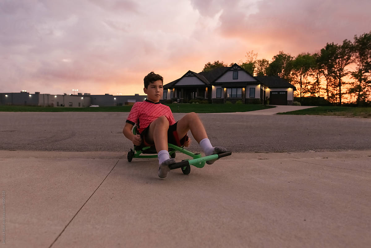 Boy riding recumbent scooter.