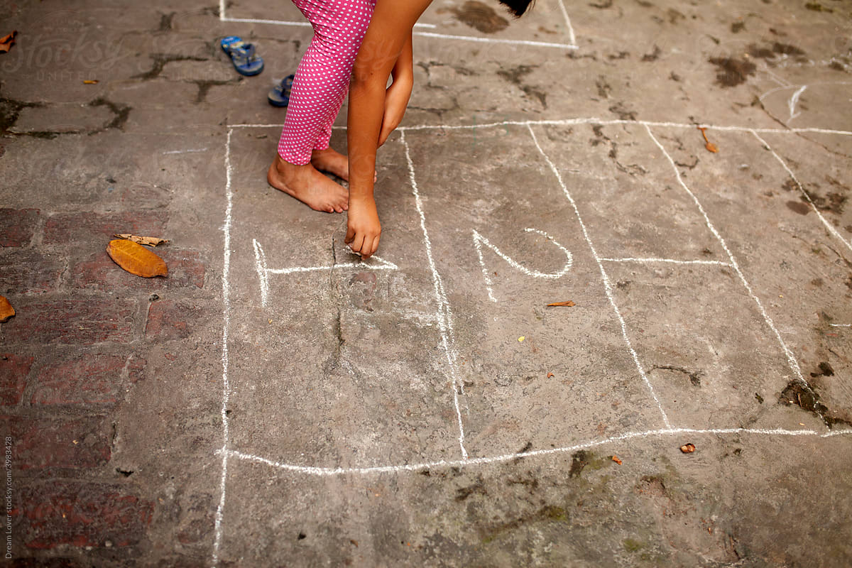 A girl writing 1,2 on ground for child\'s play