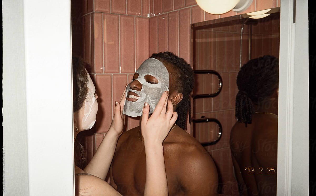 The girl helps her boyfriend to take care of the skin of the face