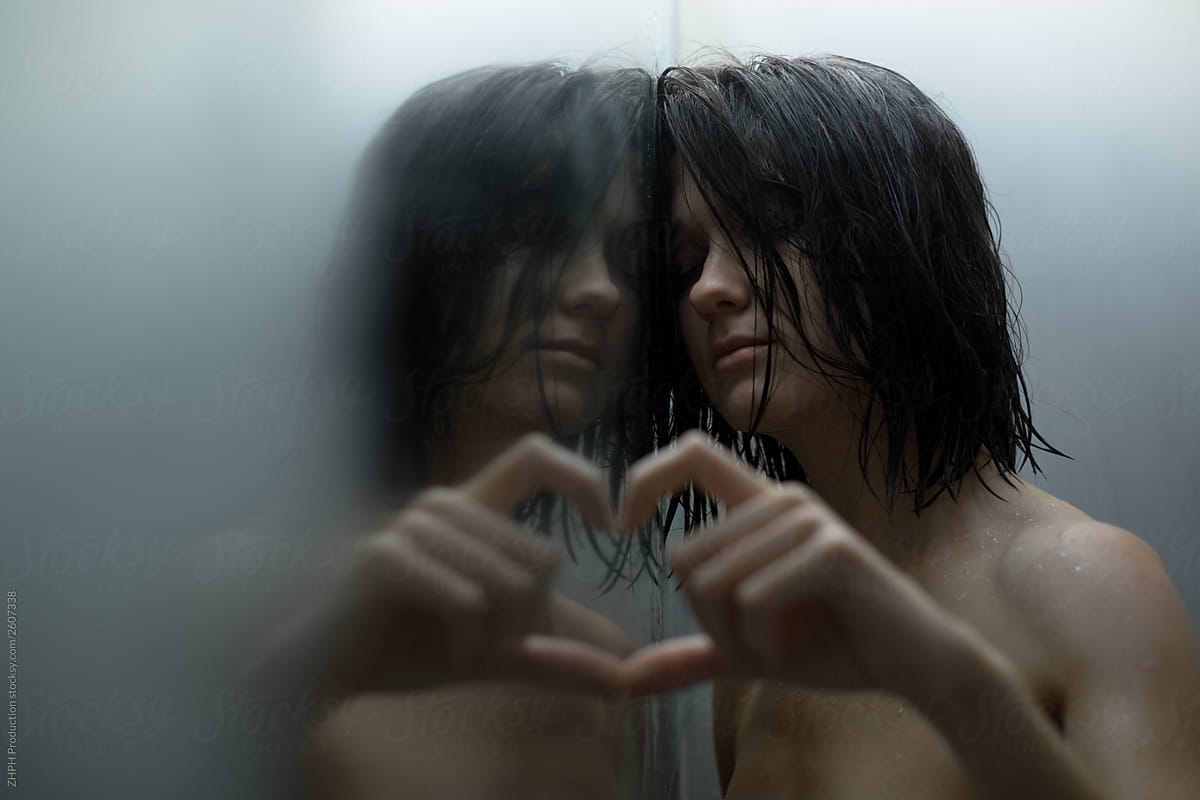 Woman in shower playing with mirror