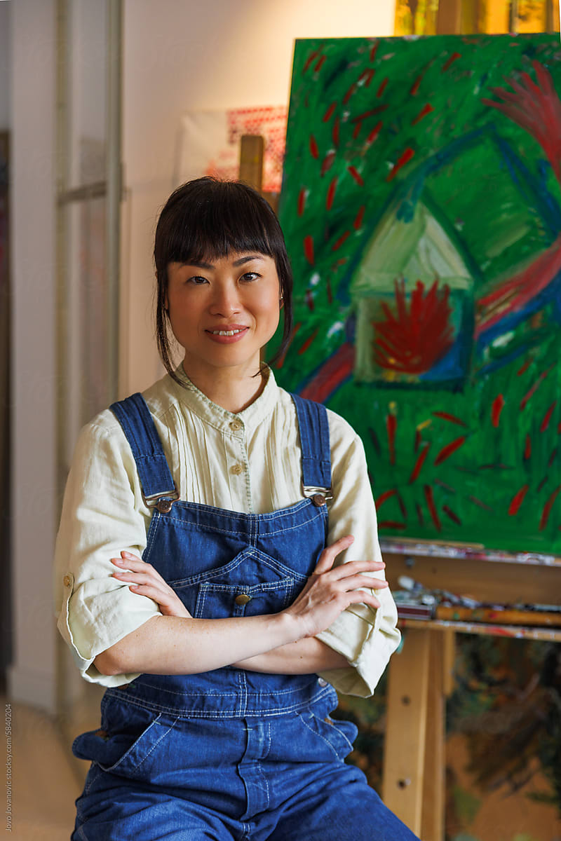 Portrait of female artist in front of her artwork