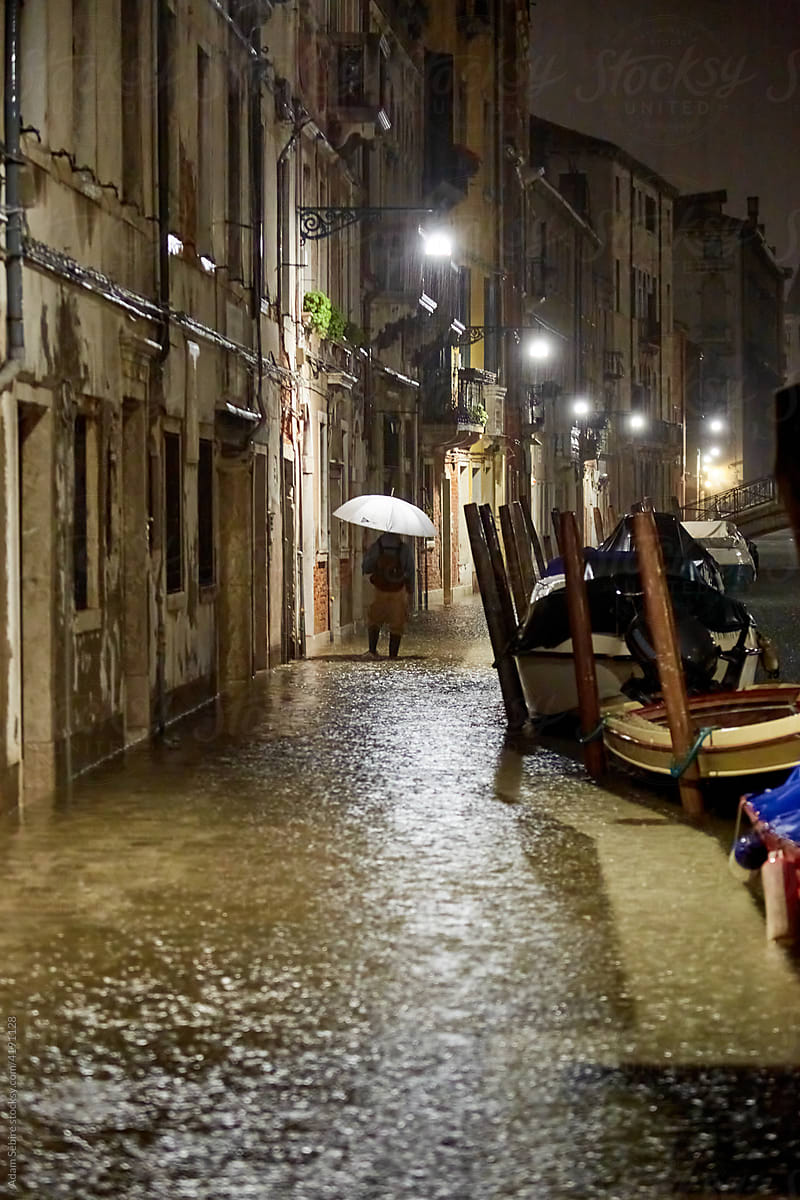 Flooding, sea level rise, Venice canal rainy night umbrella