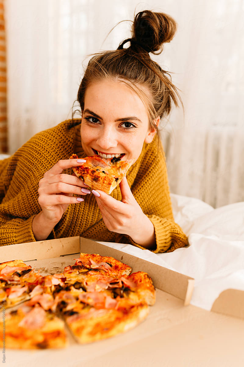 Young girl eating pizza at home