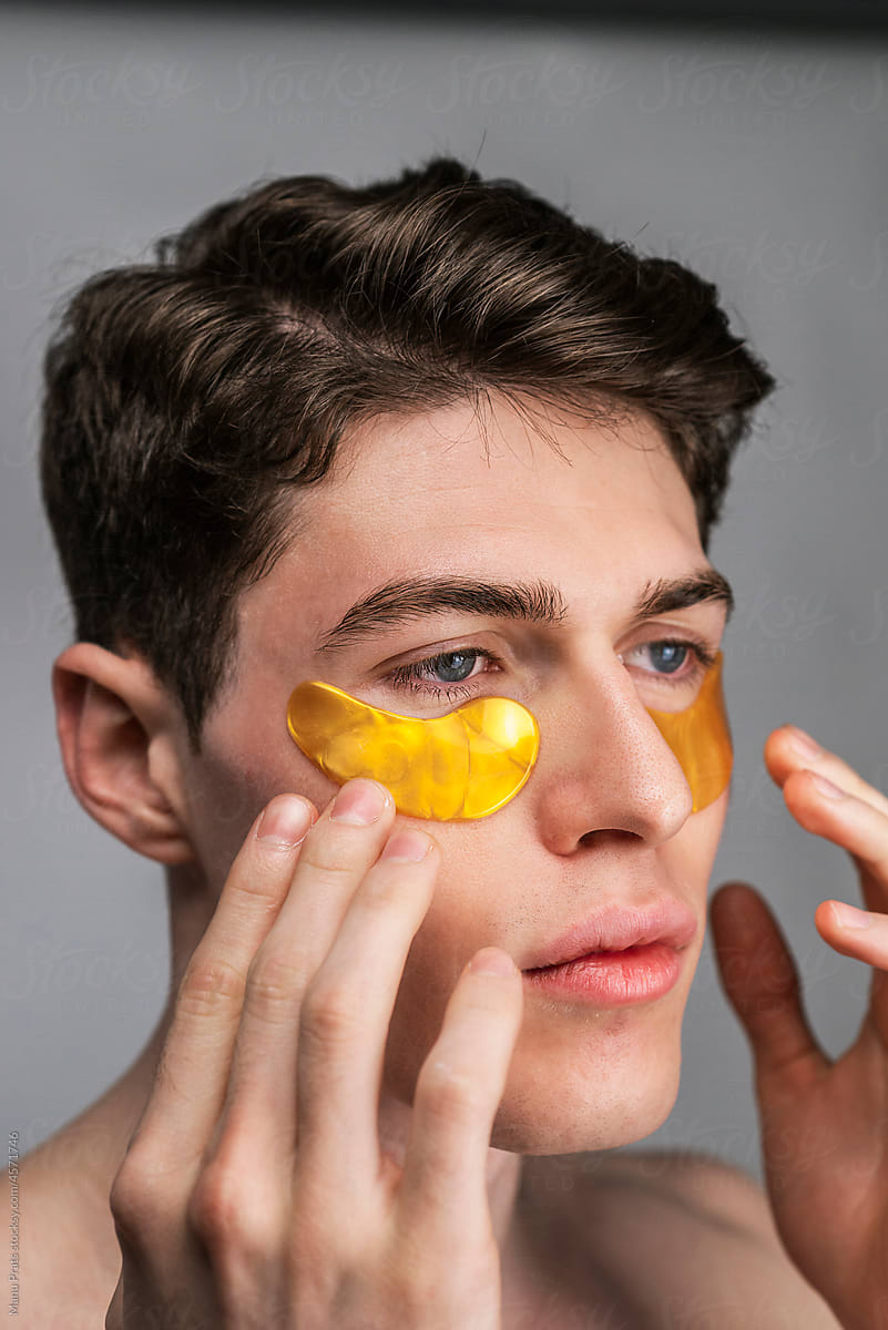 Man using under eye patch, male skin care