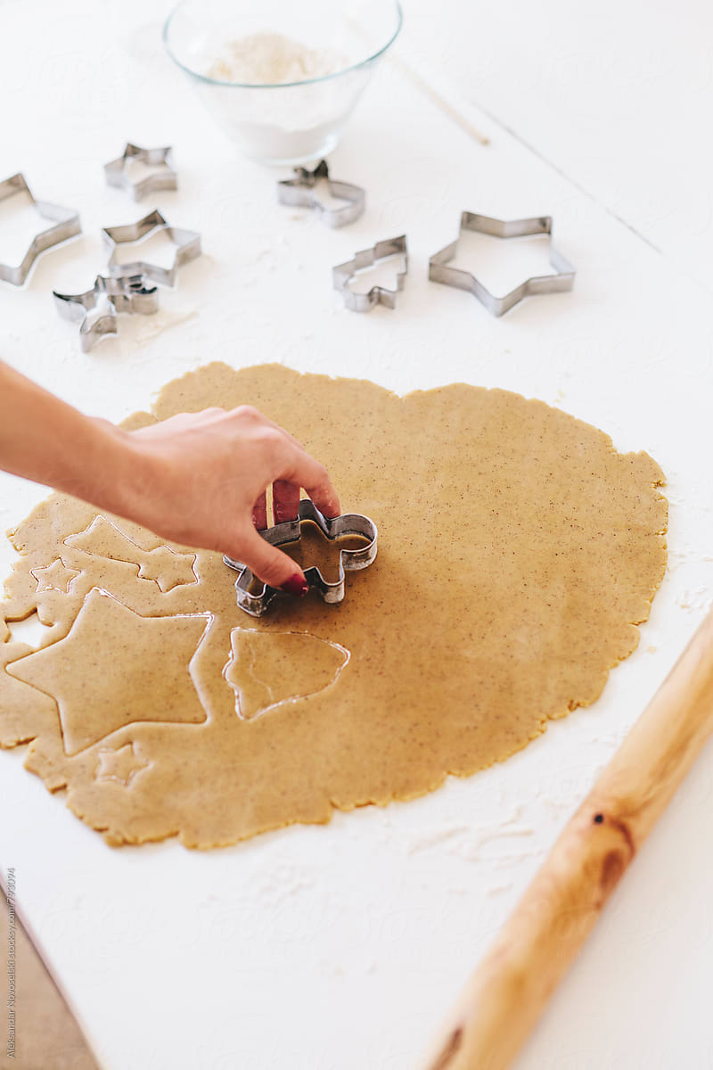 Woman shaping christmas cookies with cutters