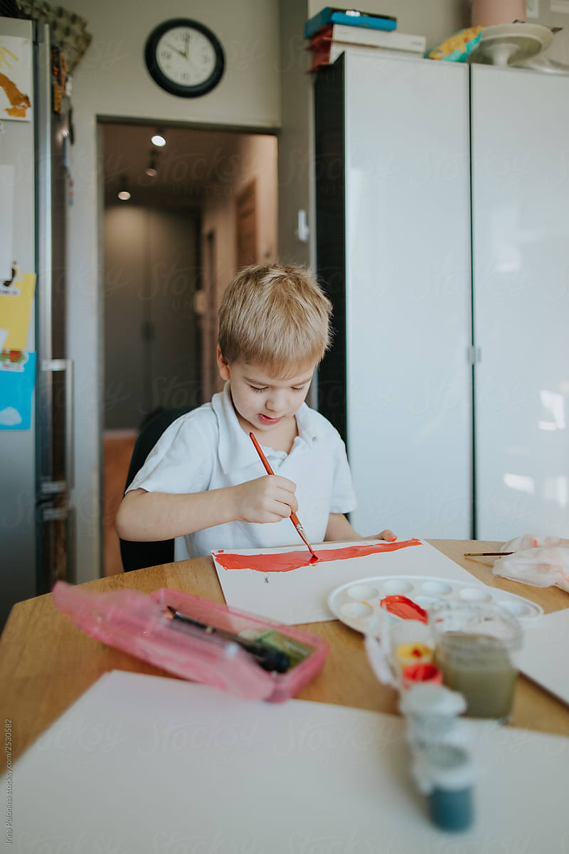 A little boy is engaged in drawing at home