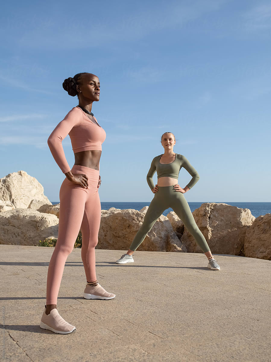 Multiracial sportswomen exercising near sea together