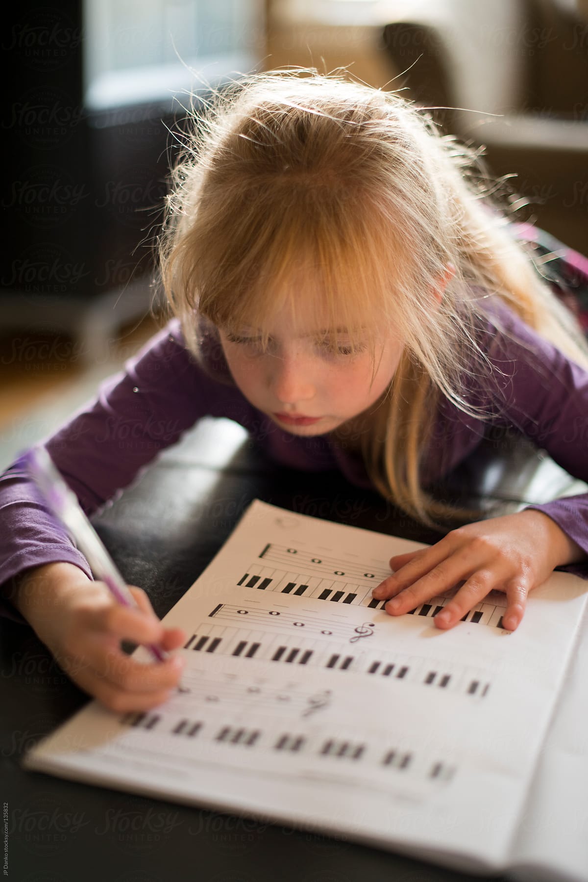 Little Girl Learning to Play Piano with Sheet Music