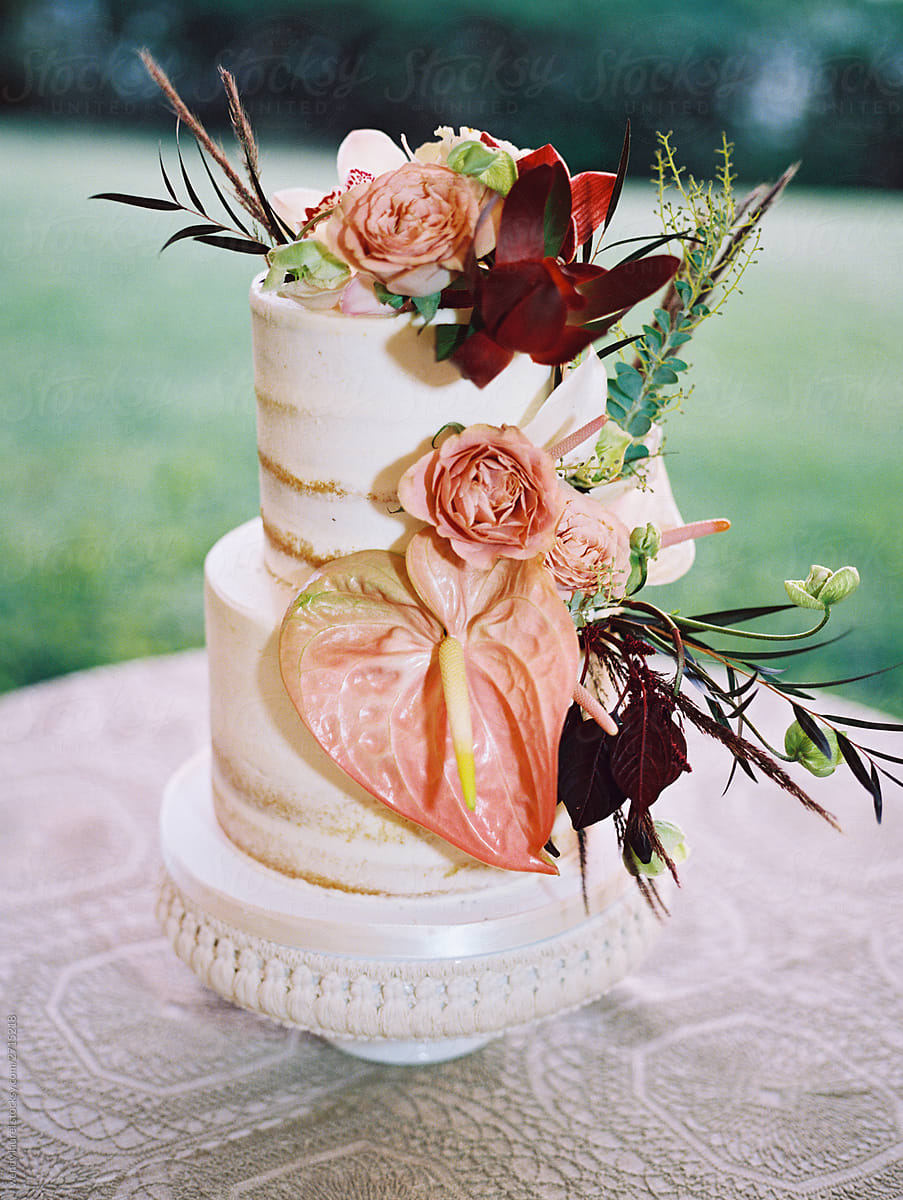 Wedding cake with tropical flowers in pinks and reds and greens