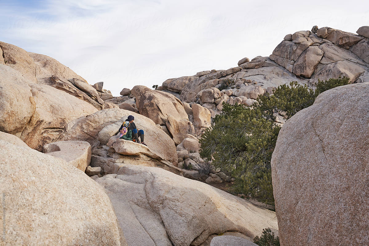 Father and son sitting amongst boulders in Joshua Tree National Park