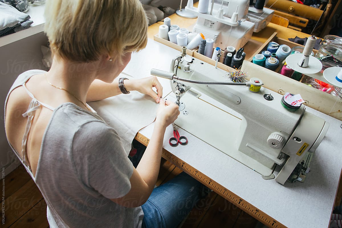 Blond Caucasian Couturier Working on Sewing Machine