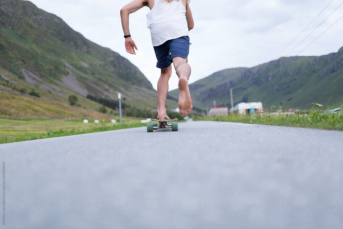 Young man takes off on his skateboard on the road