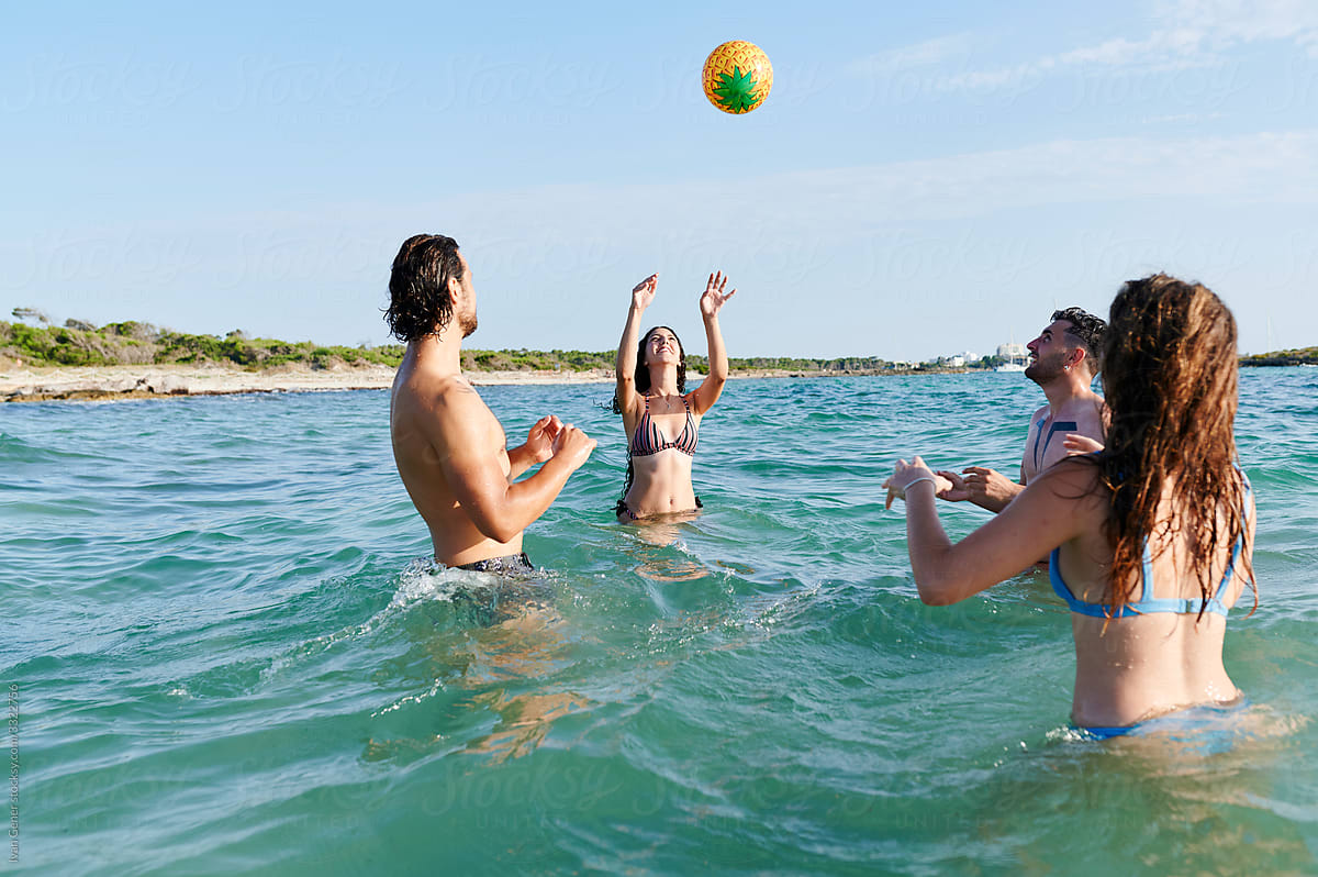 Friends tossing a ball around in the ocean
