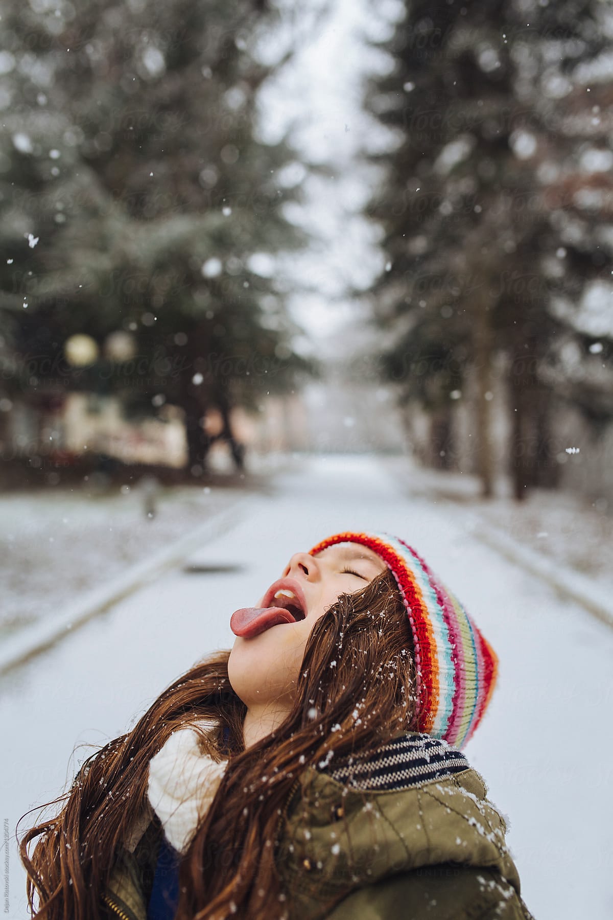 Girl enjoying snow on a snowy winter day.