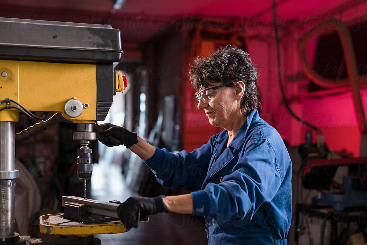 Woman working with industrial drill at workshop