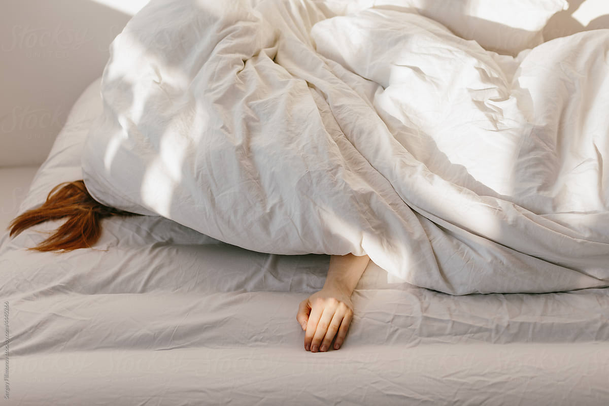 Tired woman sleep under blanket in morning