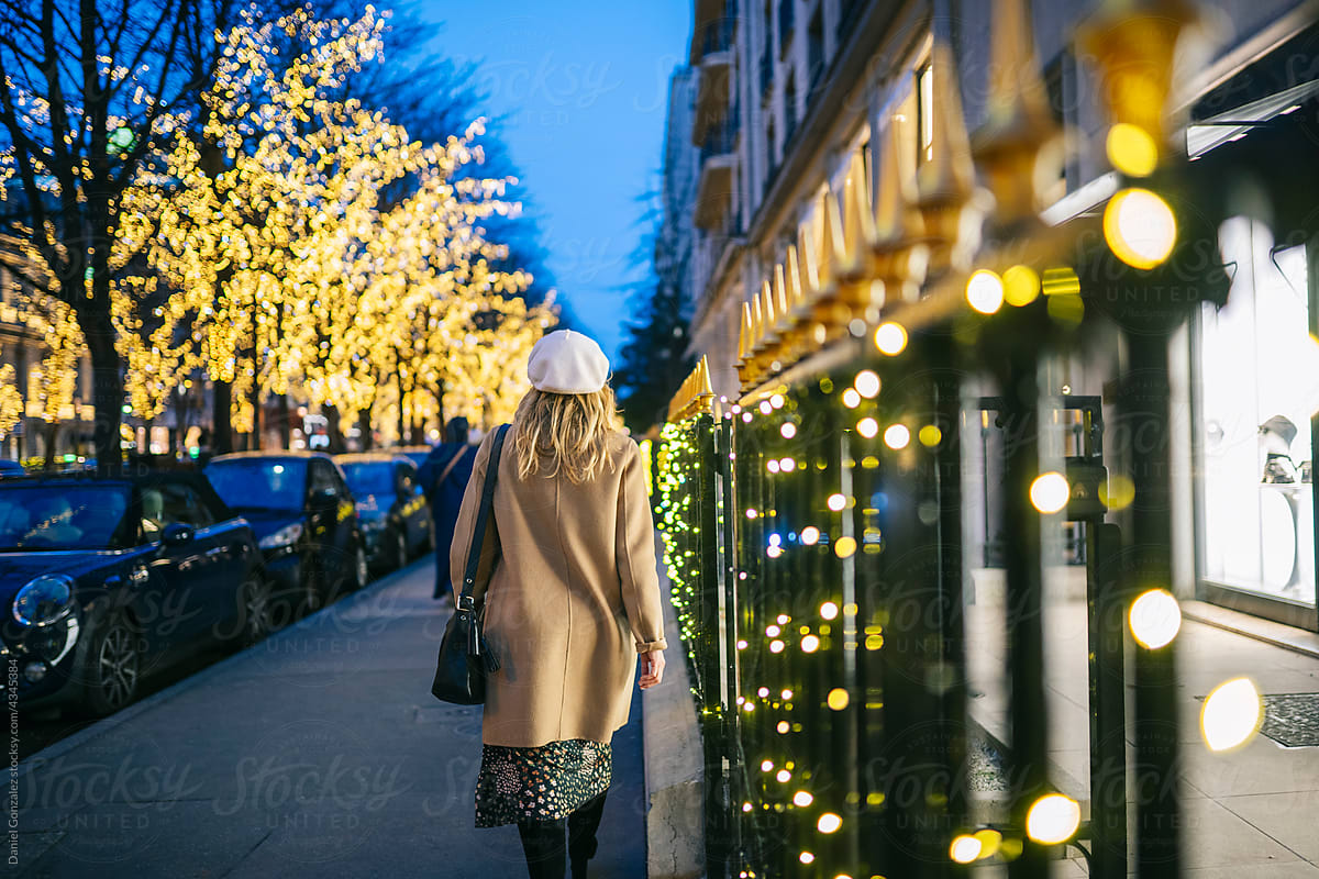 Woman walking on street decorated for Christmas