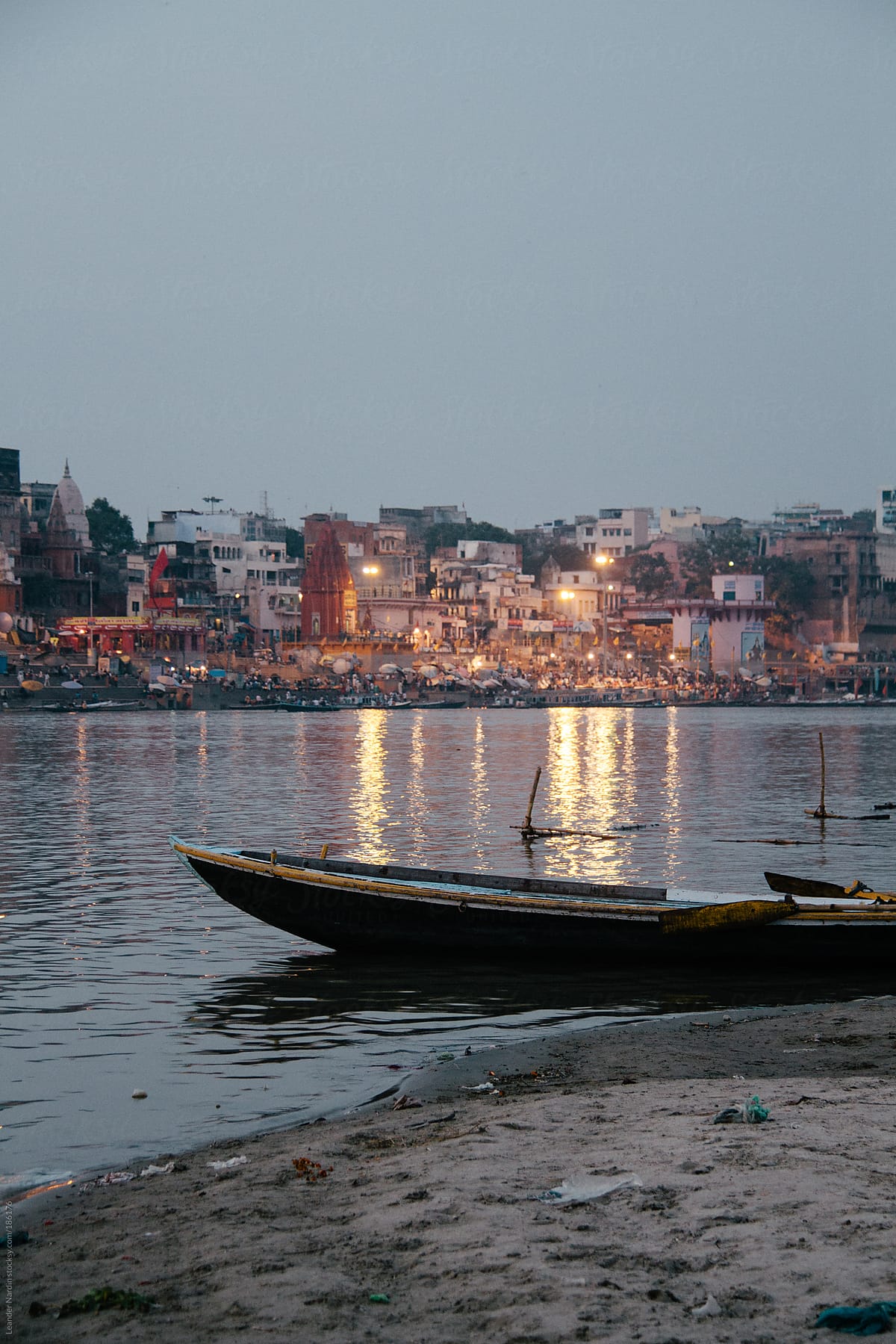 boat on the shore of the ganges with the riverside of varanasi in the back