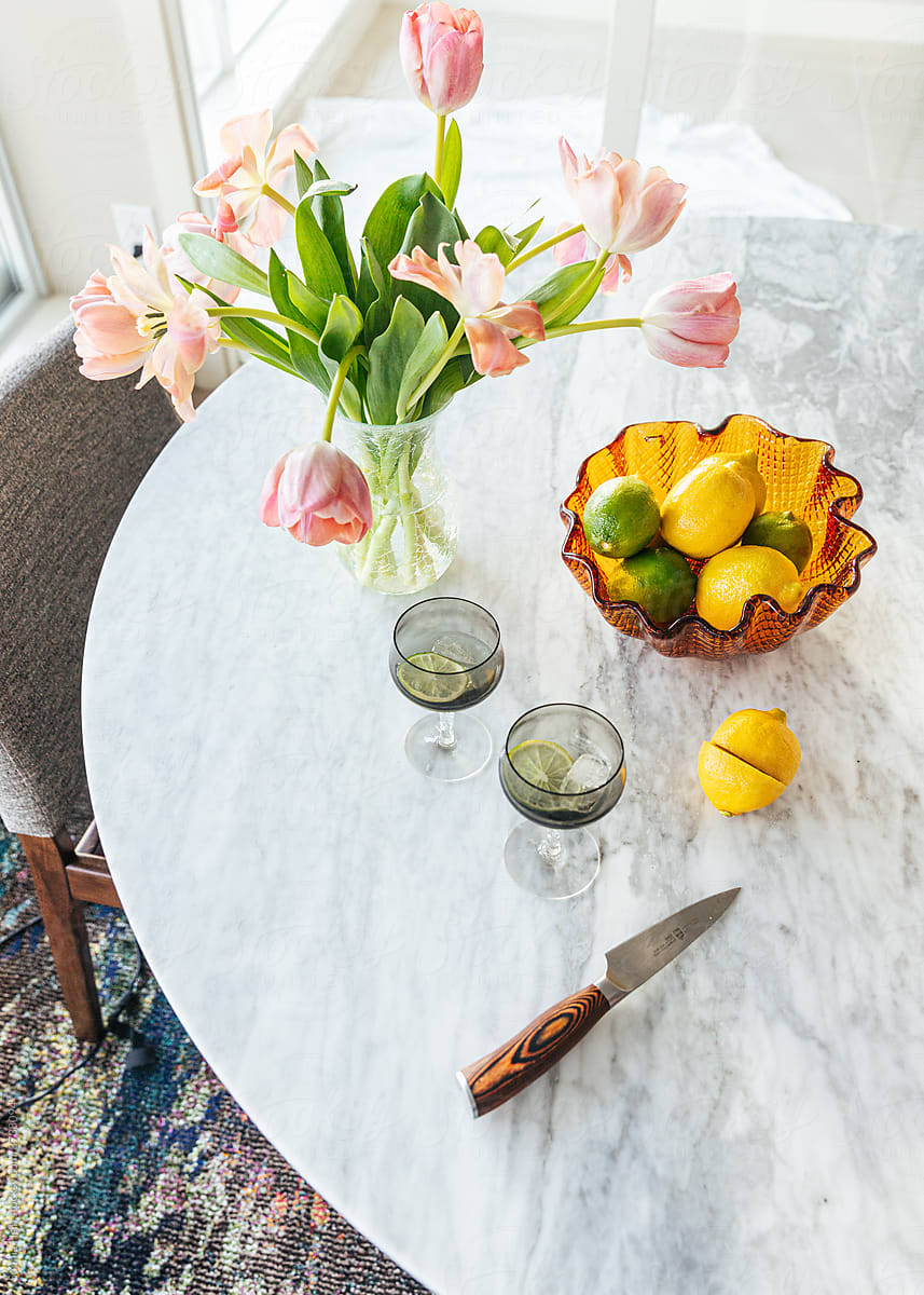 Marble table with citrus fruit and vase of tulips