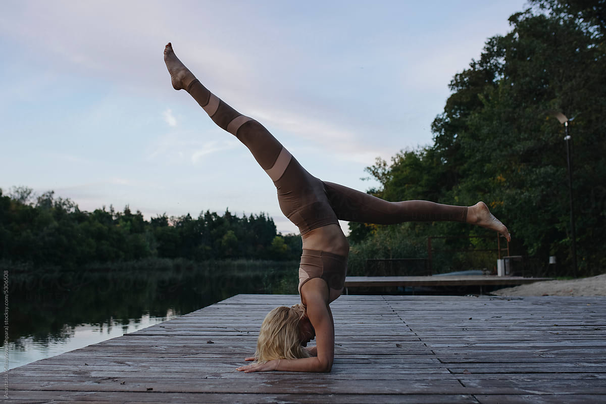 Blonde Woman Doing Yoga Handstand outside
