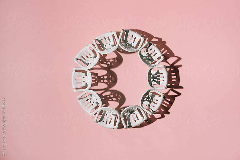 White hairs arranged in circle on pink background.