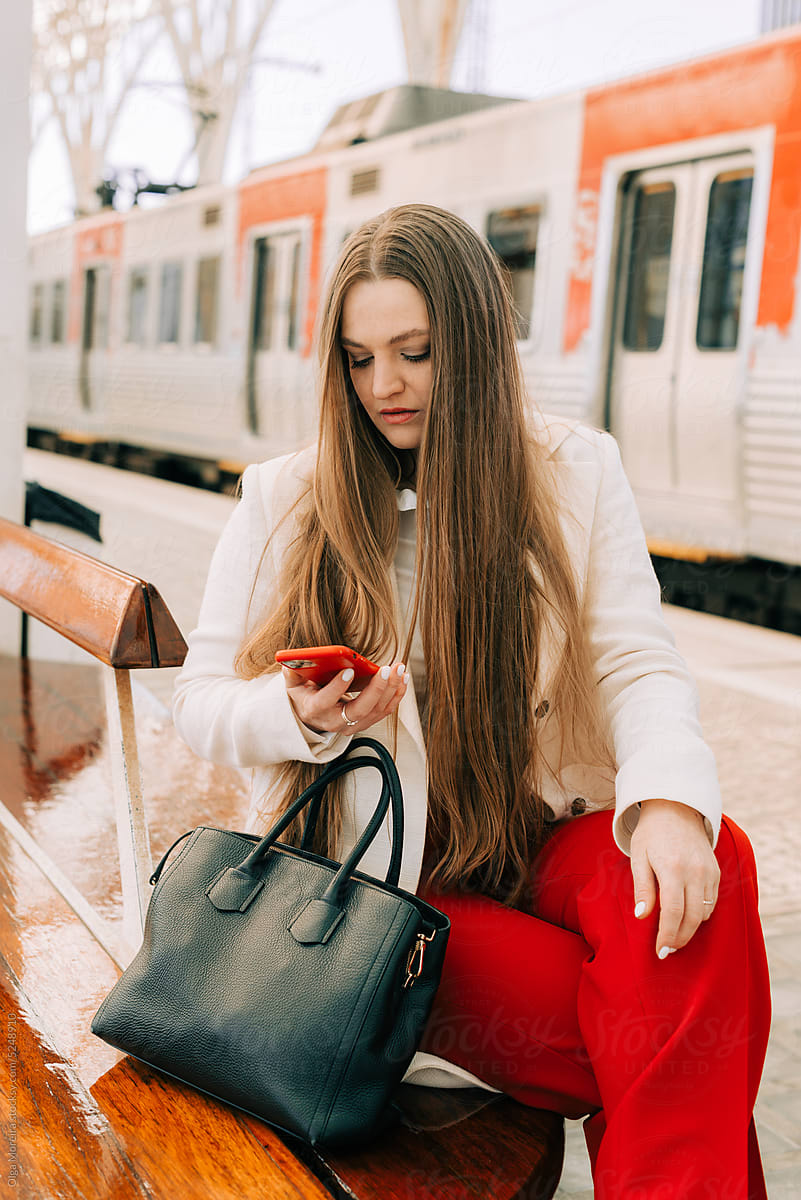 Woman using phone while waiting for train