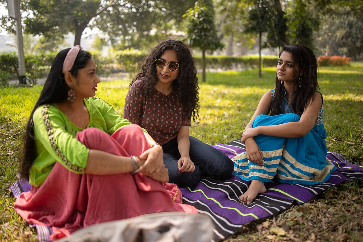 Three Indian Girl Sitting In A Park And Making Conversation
