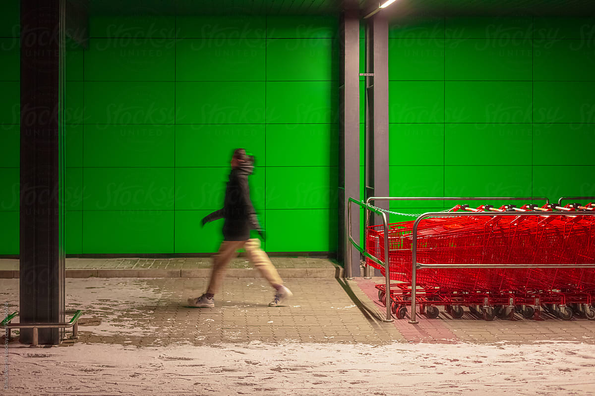 A lot of shopping carts on the background of a walking man