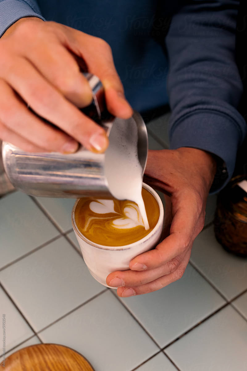 barista making the latte art of a flat white
