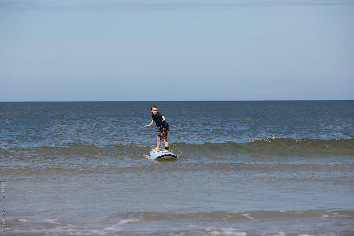 Boy surfing on calm water in Costa Rica