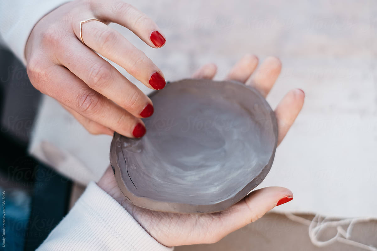 Hands forming a clay dish for ceramics production