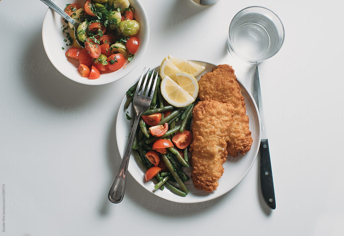 Breaded fish fillet with salad of green beans and tomatoes