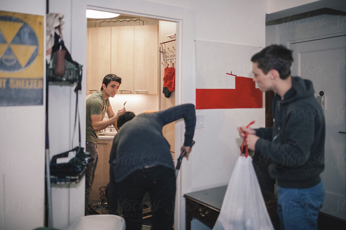 Young Student Roommates Helping Each Other Clean Their Apartment
