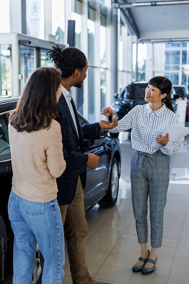 Car salesperson hands over keys to customer